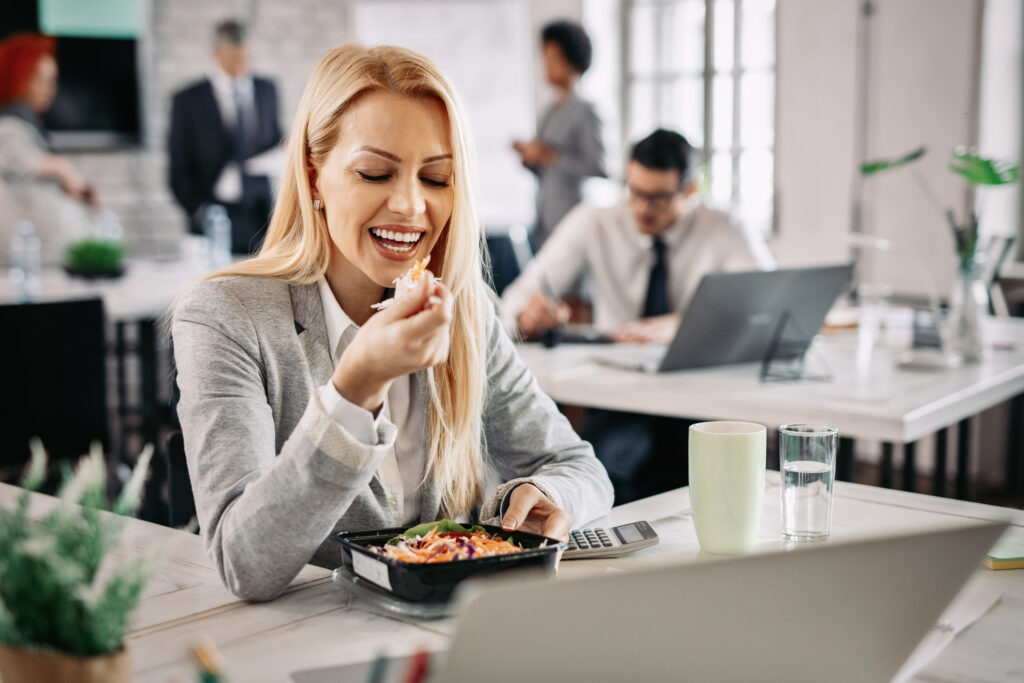 Pracownica je sałatkę na lunch w pracy